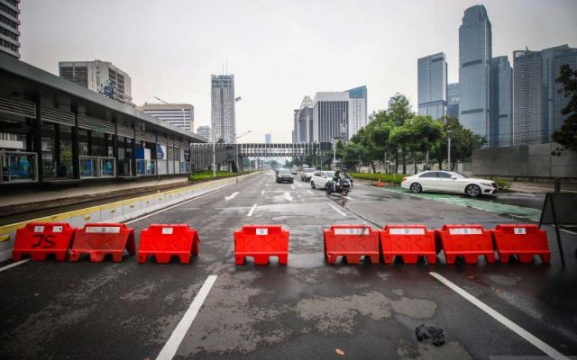 Kendaraan melintas di tempat penyekatan Pemberlakuan Pembatasan Kegiatan Masyarakat (PPKM) Darurat di Jalan Jenderal Sudirman, Jakarta, Senin (19/7/2021). Pemerintah masih mempertimbangkan rencana perpanjangan masa PPKM darurat Jawa-Bali yang akan berakhir pada Selasa (20/7/2021).  - Antara Foto/Rivan Awal Lingga/hp.