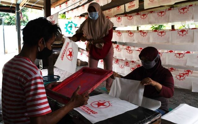 Pekerja membuat tas berbahan kain di tempat Usaha Mikro Kecil Menengah (UMKM) di Kota Madiun, Jawa Timur, Sabtu (31/7/2021). Perajin UMKM tersebut tetap bertahan untuk berproduksi meskipun saat PPKM permintaan turun dari sebelum pandemi 20.000 buah per bulan menjadi 2.000 buah per bulan dengan harga Rp9 ribu hingga Rp18 ribu per buah. ANTARA FOTO - Siswowidodo