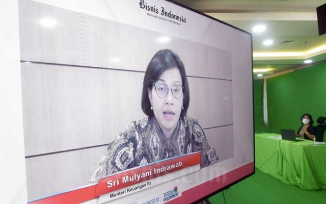 Menteri Keuangan Sri Mulyani Indrawati (dalam layar) disaksikan Pemimpin Redaksi Bisnis Indonesia Maria Y. Benyamin memberikan pemaparan dalam webinar  Mid Year Economic Outlook 2021: Prospek Ekonomi Indonesia Pasca Stimulus, Relaksasi dan Vaksinasi di Jakarta, Rabu (7/7/2021). Bisnis - Fanny Kusumawardhani