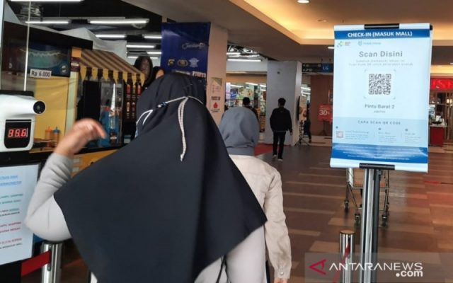 Pengunjung mengukur suhu tubuh dan scan QR Code PeduliLindungi sebelum masuk ke mal - Antara