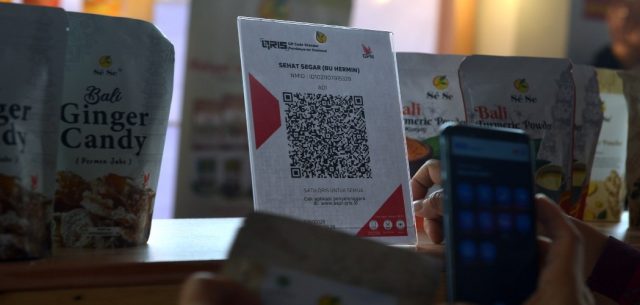 Pengunjung bertransaksi pembayaran produk UMKM secara digital dengan menggunakan Quick Response Code Indonesian Standard (QRIS) dalam rangkaian kegiatan "Bali Jagaditha Culture Week" di Denpasar, Bali, Rabu (6/10/2021).  ANTARA FOTO - Fikri Yus