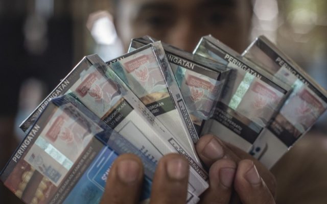 Pedagang menunjukkan bungkus rokok bercukai di Jakarta, Kamis (10/12/2020). Kementerian Keuangan mengumumkan kenaikan tarif cukai rokok sebesar 12,5 persen yang berlaku pada 2021. - ANTARA FOTO/Aprillio Akbar