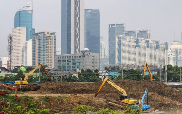 Sejumlah alat berat beroperasi dengan latar belakang gedung bertingkat di Jakarta, Kamis (26/8/2021). - Antara