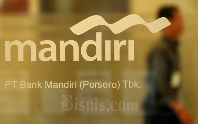 Karyawan melintas di dekat logo milik Bank Mandiri di Jakarta, Kamis (8/8/2019). Bisnis - Arief Hermawan P 