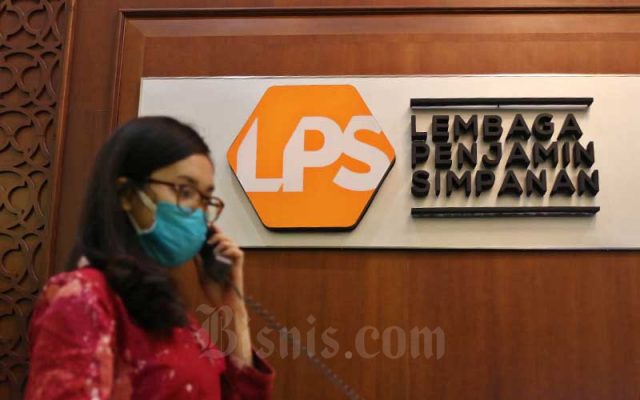 Karyawan beraktivitas di dekat logo Lembaga Penjamin Simpanan (LPS) di Jakarta, Jumat (10/7/2020). Bisnis - Eusebio Chrysnamurti