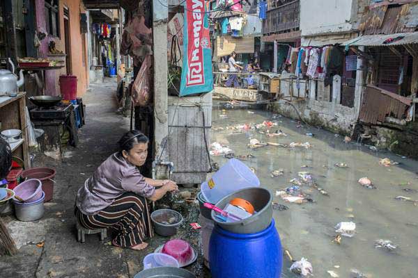 Warga beraktivitas di kawasan permukiman padat penduduk, di bantaran Kali Krukut Bawah, Kebon Melati, Tanah Abang, Jakarta, Jumat (20/7/2018). - ANTARA/Aprillio Akbar